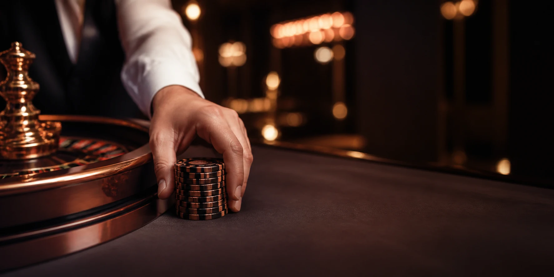 Dealerhand mit frischem Chipstapel am Roulettekessel